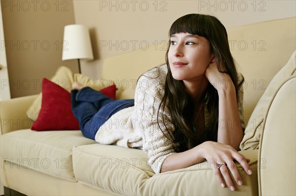 Mixed race woman laying on sofa