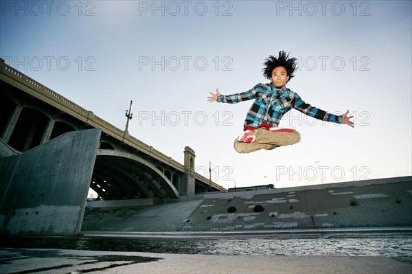 Asian man break dancing under overpass