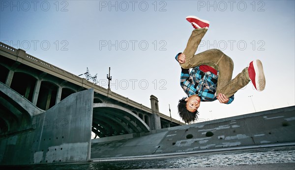 Asian man break dancing under overpass