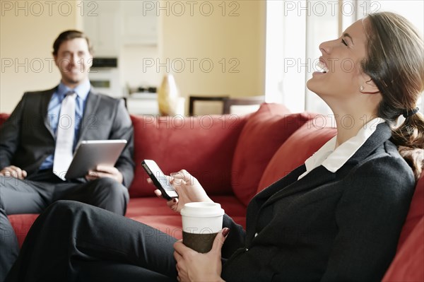 Business people relaxing on sofa together