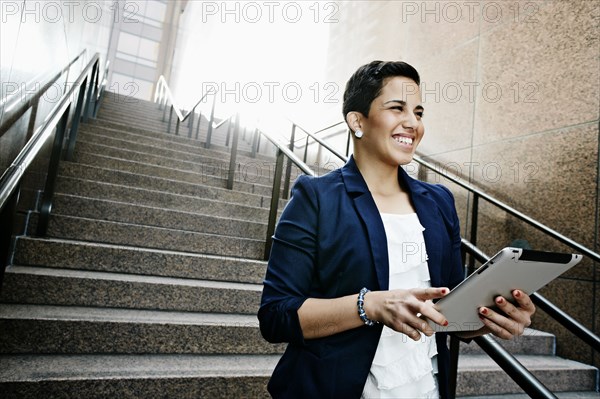 Hispanic businesswoman using tablet computer