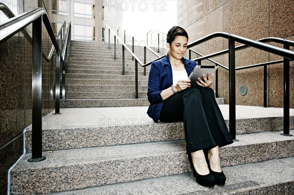 Hispanic businesswoman using tablet computer