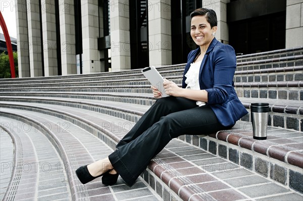 Hispanic businesswoman using tablet computer