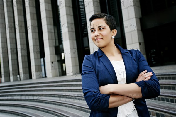 Hispanic businesswoman standing on steps