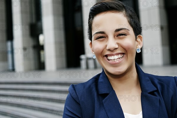 Hispanic businesswoman laughing outdoors