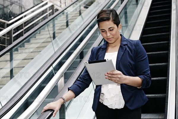 Hispanic businesswoman using tablet computer