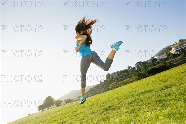 Mixed race woman running in park