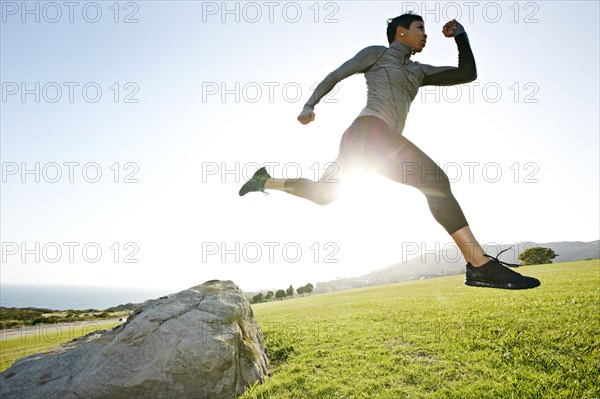 Black woman running in rural landscape