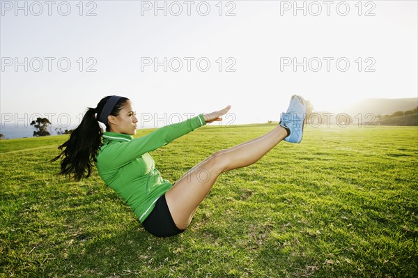 Hispanic woman exercising in field