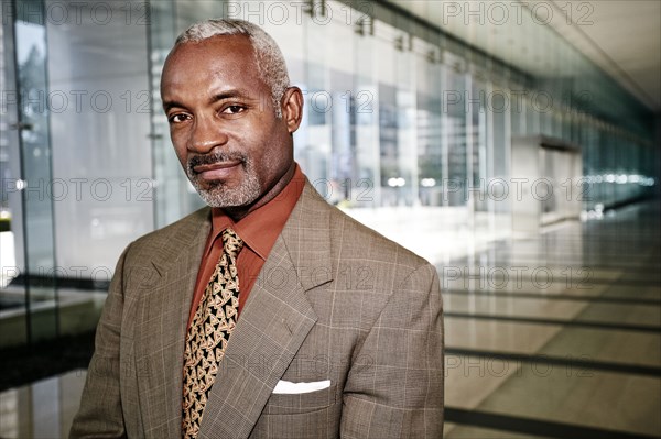 Black businessman smiling in office corridor