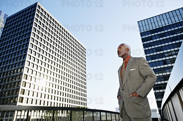 Black businessman standing on urban walkway