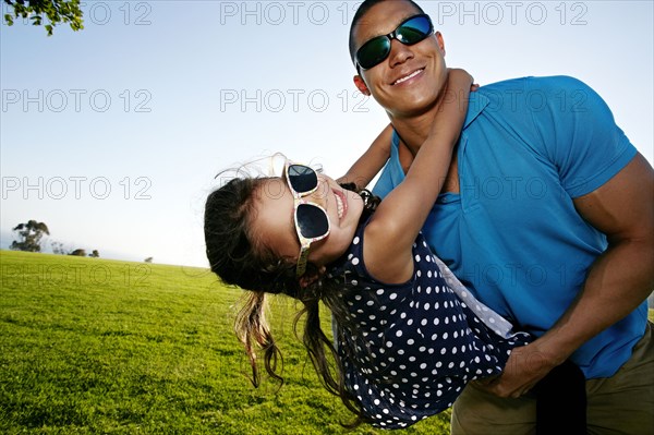 Father and daughter playing in field