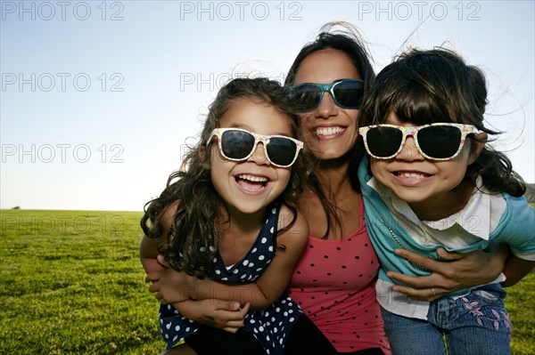 Mother and daughters smiling in field