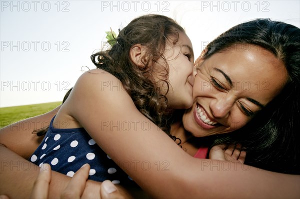 Girl kissing mother on cheek