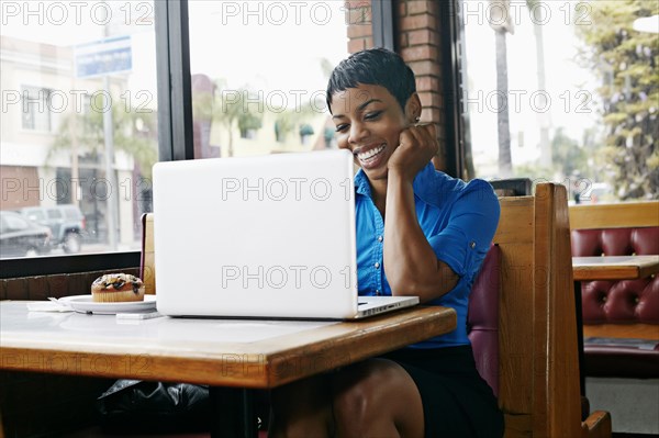 African American businesswoman using laptop in restaurant