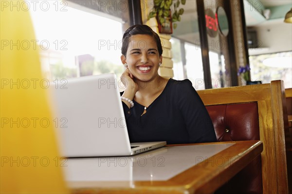 Hispanic businesswoman smiling in restaurant