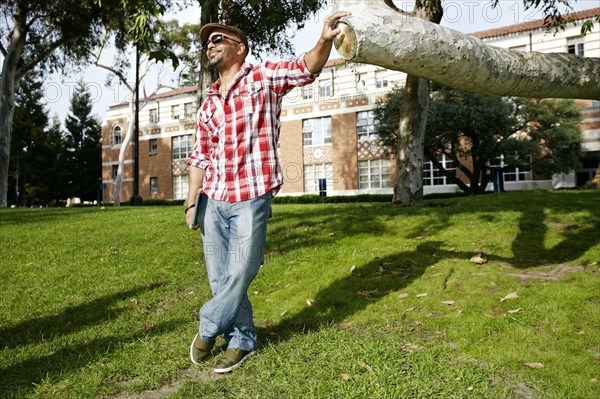 Man leaning against tree branch in park