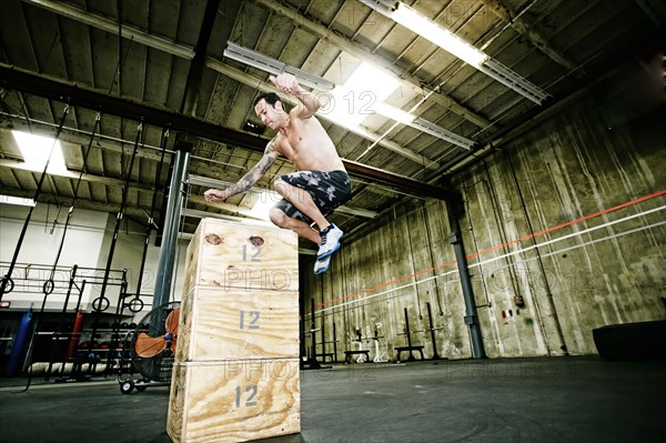 Mixed race man exercising in gym