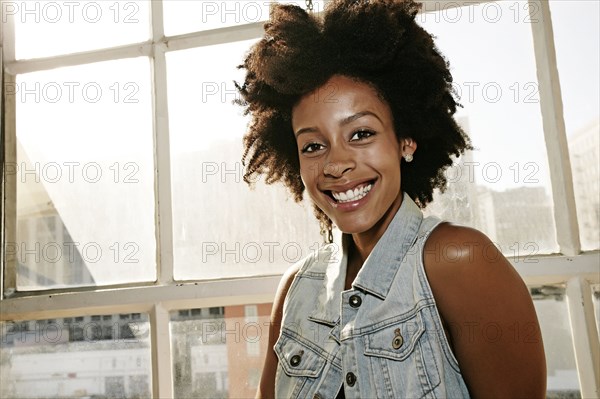 Mixed race woman smiling in window