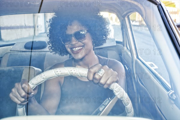 Mixed race woman driving vintage car