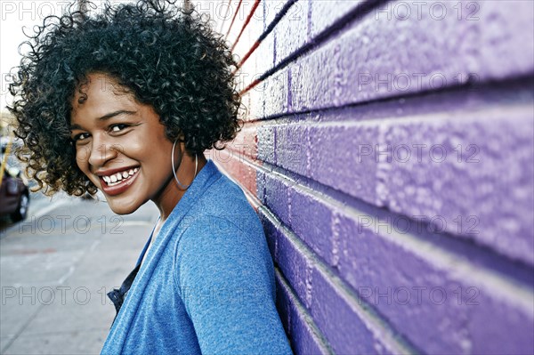 Mixed race woman standing by colorful wall