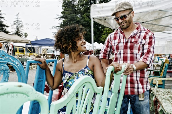 Couple buying colorful chairs at flea market