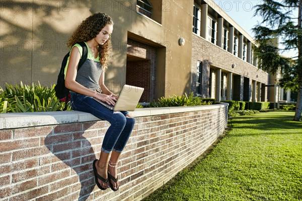 Mixed race student using laptop