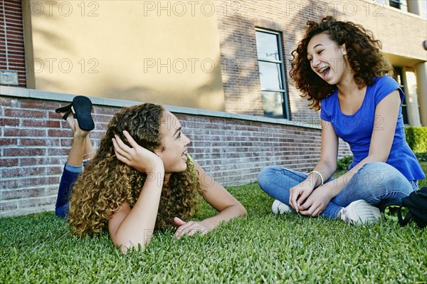 Mixed race girls talking in grass
