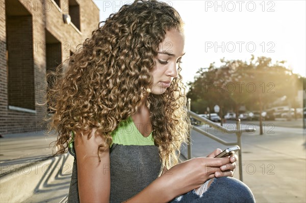 Mixed race girl using cell phone