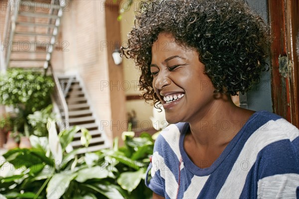 Mixed race woman sitting in window