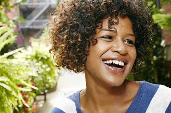 Mixed race woman smiling in courtyard