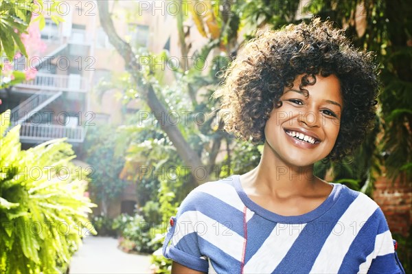 Mixed race woman smiling in courtyard