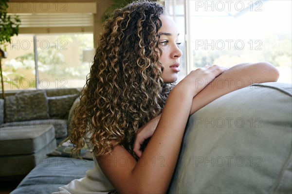 Mixed race girl sitting on sofa