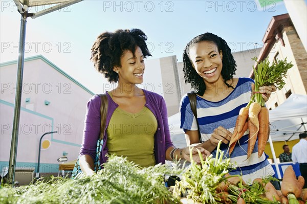 Women shopping together at vegetable stand