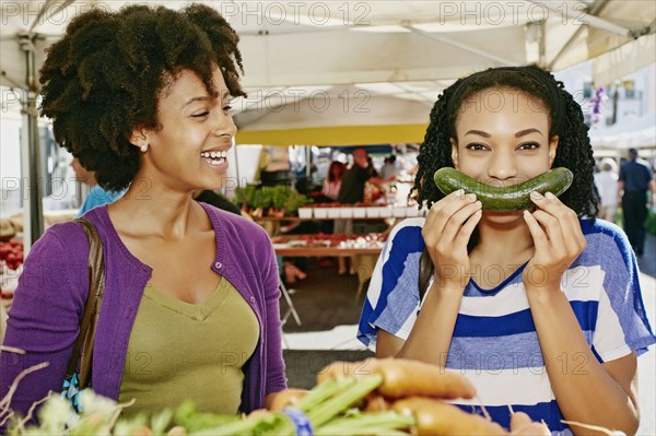 Women smiling together at outdoor market