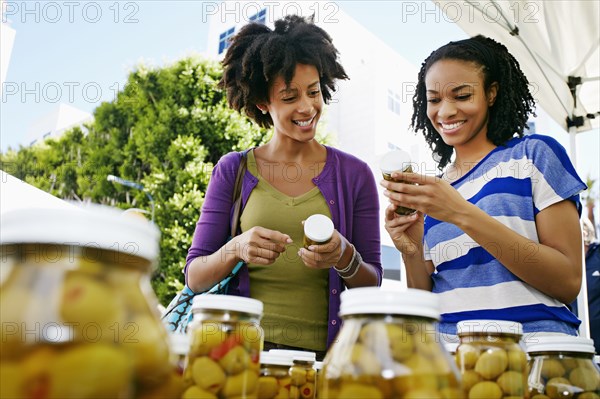 Women smiling together at outdoor market