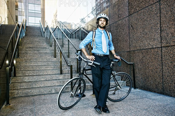 Caucasian businessman with bicycle on urban stairs