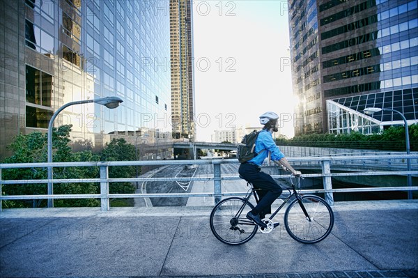 Caucasian businessman riding bicycle on urban street