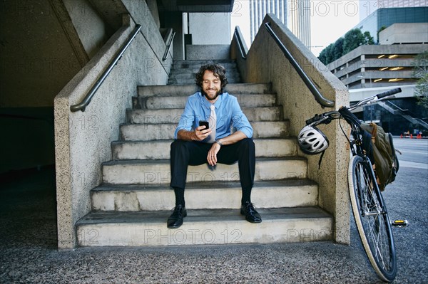 Caucasian businessman with bicycle using cell phone