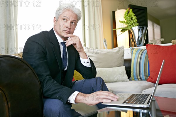 Caucasian businessman working in living room