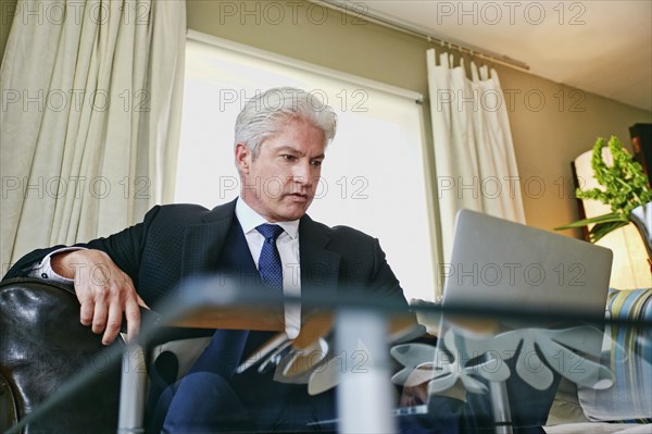 Caucasian businessman working in living room