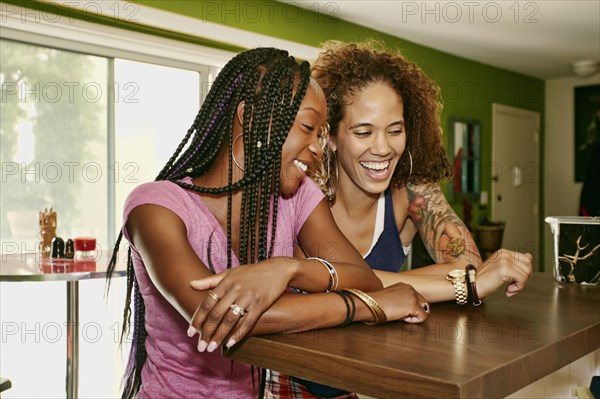 Homosexual couple laughing together in kitchen