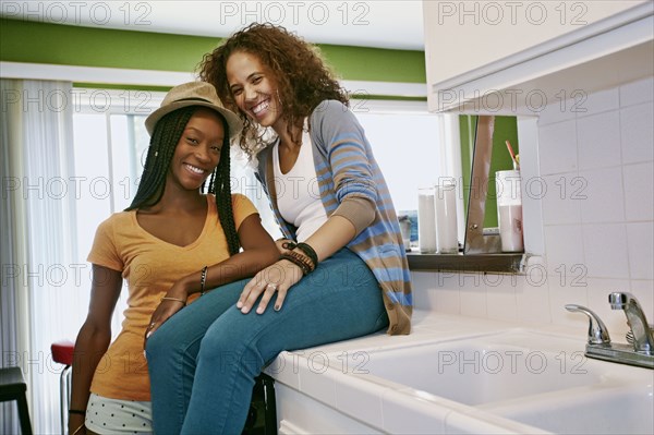 Homosexual couple smiling together in kitchen