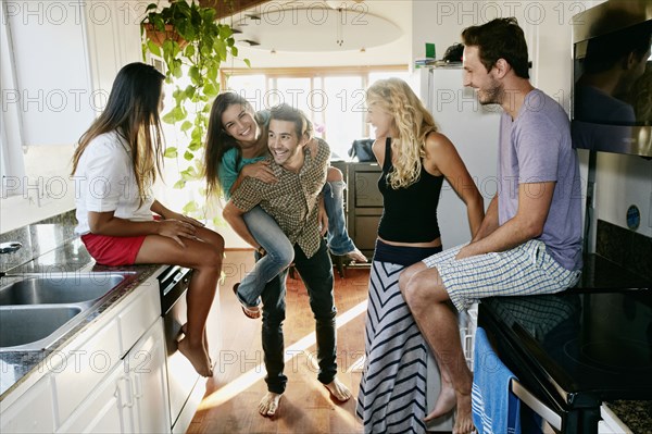 Friends relaxing together in kitchen