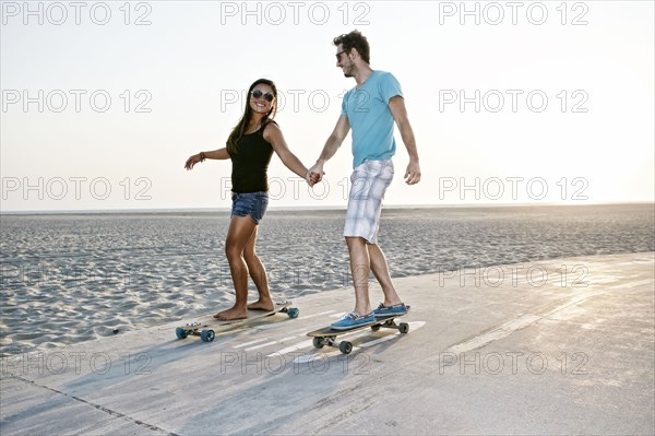 Couple skating on beach