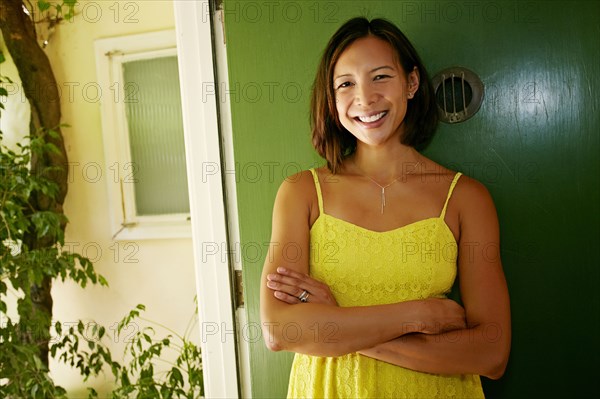 Mixed race woman smiling at front door