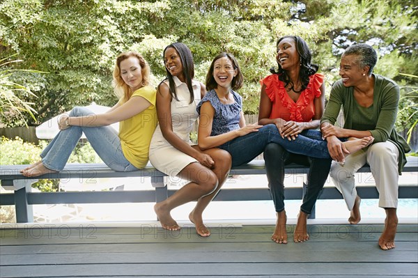 Women smiling together on bench