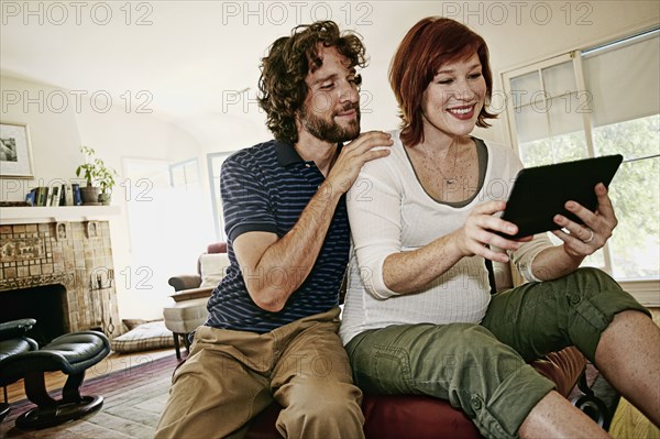 Pregnant Caucasian couple using digital tablet