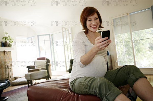 Pregnant Caucasian woman using cell phone