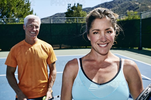 Caucasian couple standing on tennis court